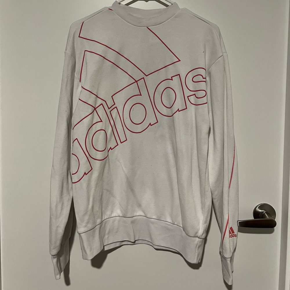 White Adidas crew neck with pink lettering and seam details.